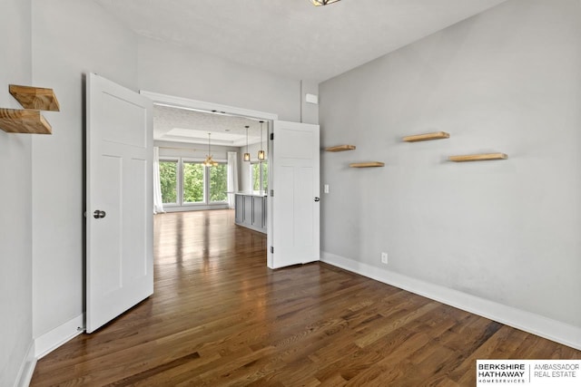 19014 Pratt Cir, Elkhorn, NE 68022 - empty room featuring a chandelier and dark wood-style floors
