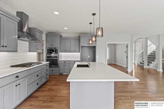 19014 Pratt Cir, Elkhorn, NE 68022 - kitchen with gray cabinetry, appliances with stainless steel finishes, wall chimney range hood, recessed lighting, and light wood-type flooring