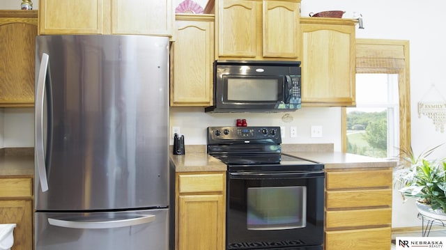 1933 Redstone Rd, Lincoln, NE 68521 - kitchen with black appliances, light brown cabinetry, and light countertops