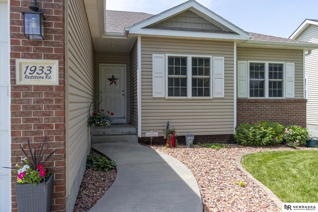 1933 Redstone Rd, Lincoln, NE 68521 - view of exterior entry featuring a shingled roof and brick siding