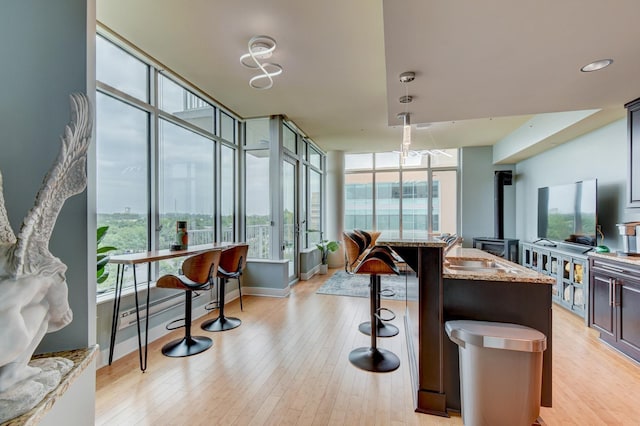 444 Riverfront Plz Unit 501, Omaha, NE 68102 - kitchen featuring light stone counters, a breakfast bar, and light wood finished floors