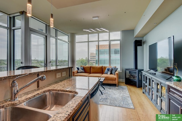 444 Riverfront Plz Unit 501, Omaha, NE 68102 - kitchen featuring plenty of natural light, light wood-style floors, light stone counters, and a wood stove