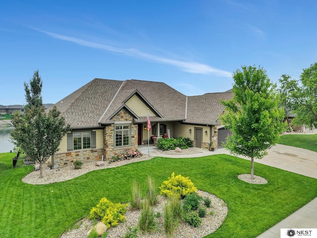 820 N 100th St, Lincoln, NE 68527 - craftsman house with stone siding, an attached garage, a front yard, driveway, and a shingled roof