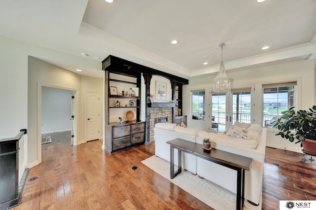 820 N 100th St, Lincoln, NE 68527 - living area featuring a raised ceiling, a stone fireplace, hardwood / wood-style flooring, a chandelier, and recessed lighting