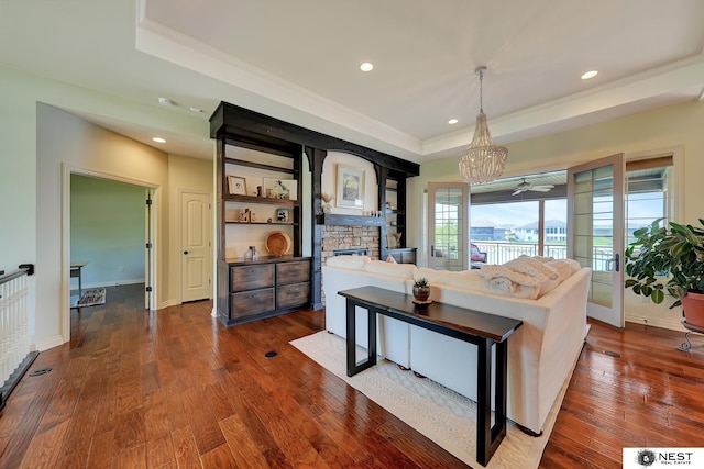 820 N 100th St, Lincoln, NE 68527 - living area featuring a tray ceiling, a stone fireplace, a chandelier, dark wood-style floors, and recessed lighting