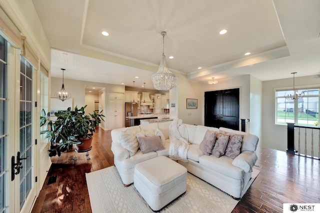 820 N 100th St, Lincoln, NE 68527 - living room featuring a chandelier, wood-type flooring, a tray ceiling, recessed lighting, and crown molding