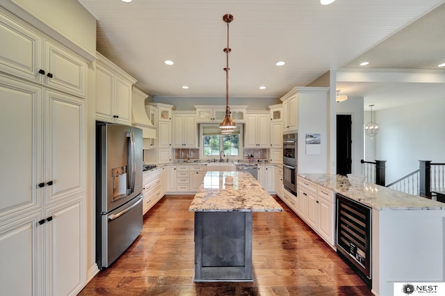 820 N 100th St, Lincoln, NE 68527 - kitchen with stainless steel appliances, wine cooler, a kitchen island, wood finished floors, and recessed lighting