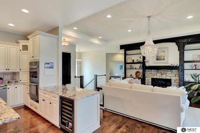 820 N 100th St, Lincoln, NE 68527 - kitchen featuring beverage cooler, a chandelier, stainless steel appliances, light stone counters, and open floor plan