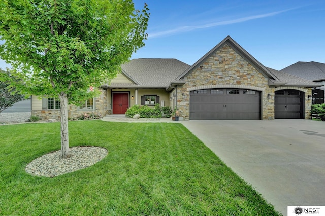 820 N 100th St, Lincoln, NE 68527 - view of front of home with stone siding, an attached garage, a front yard, and driveway