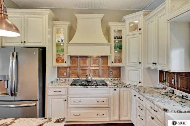 820 N 100th St, Lincoln, NE 68527 - kitchen featuring stainless steel fridge with ice dispenser, gas cooktop, wall chimney range hood, and light stone countertops