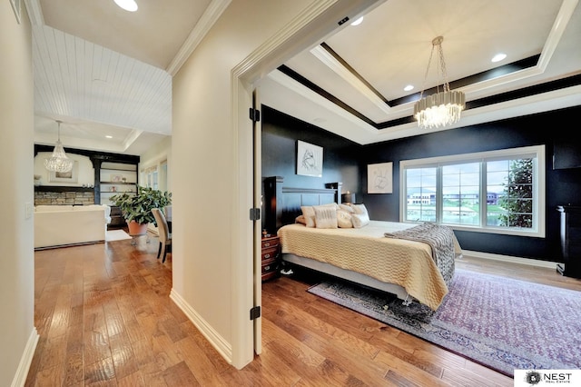 820 N 100th St, Lincoln, NE 68527 - bedroom featuring a raised ceiling, a chandelier, wood finished floors, ornamental molding, and recessed lighting