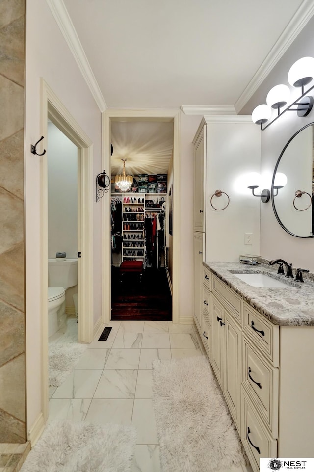 820 N 100th St, Lincoln, NE 68527 - bathroom with a chandelier, ornamental molding, vanity, marble look tile flooring, and a spacious closet