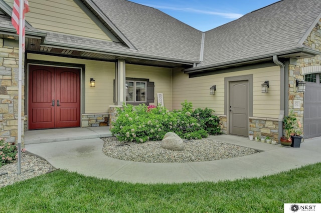 820 N 100th St, Lincoln, NE 68527 - property entrance with stone siding, roof with shingles, and an attached garage