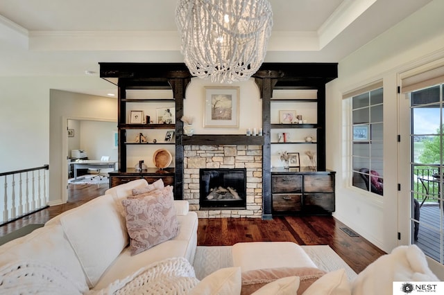 820 N 100th St, Lincoln, NE 68527 - living area with dark wood-style floors, ornamental molding, a stone fireplace, a chandelier, and a tray ceiling