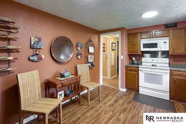 1817 Holling Dr, Omaha, NE 68144 - kitchen with white appliances, brown cabinets, light wood finished floors, and a textured ceiling