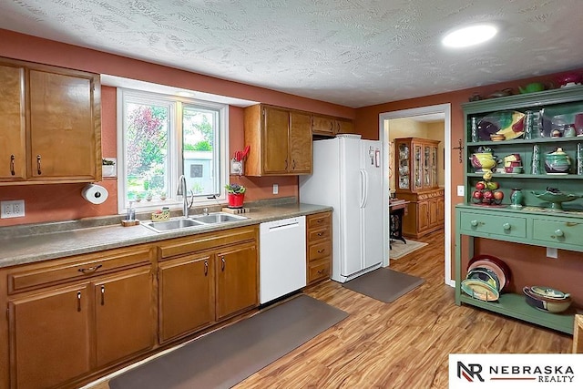 1817 Holling Dr, Omaha, NE 68144 - kitchen featuring white appliances, light wood-style flooring, brown cabinets, and a textured ceiling