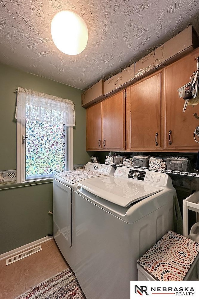 1817 Holling Dr, Omaha, NE 68144 - washroom featuring cabinet space, washing machine and clothes dryer, and a textured ceiling