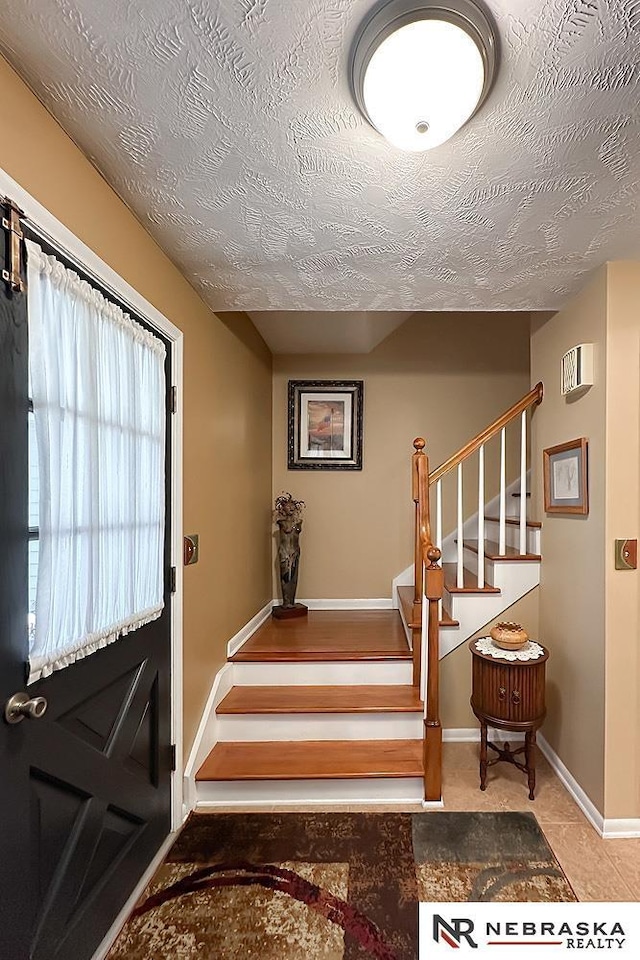 1817 Holling Dr, Omaha, NE 68144 - entryway with stairway and a textured ceiling