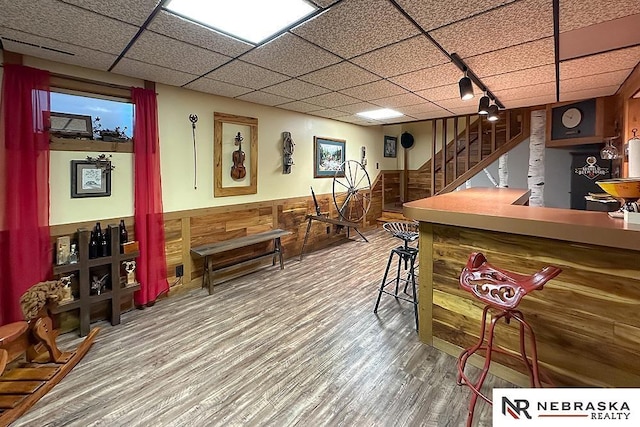 1817 Holling Dr, Omaha, NE 68144 - playroom with wainscoting, a drop ceiling, wood finished floors, and wood walls