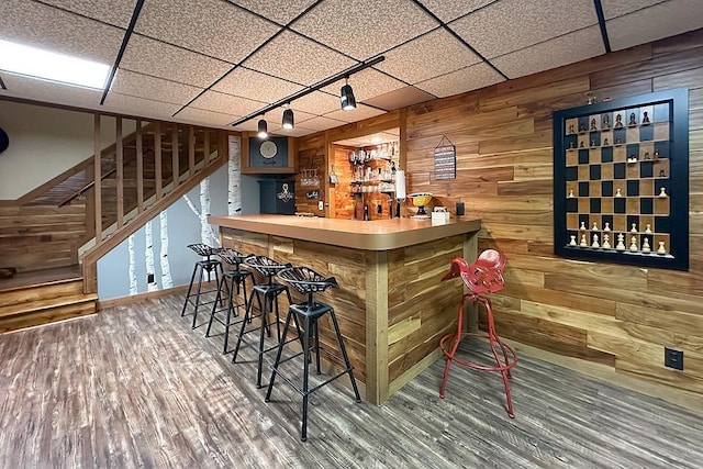 1817 Holling Dr, Omaha, NE 68144 - indoor dry bar featuring wood walls, stairs, wood finished floors, and a paneled ceiling