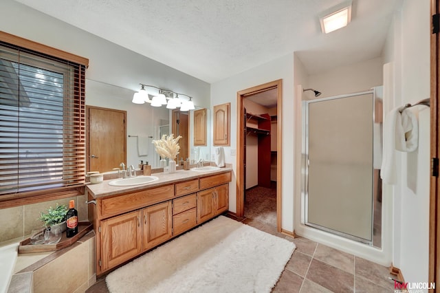 4630 Eagle Ridge Rd, Lincoln, NE 68516 - full bath with a stall shower, double vanity, a walk in closet, a textured ceiling, and tile patterned flooring