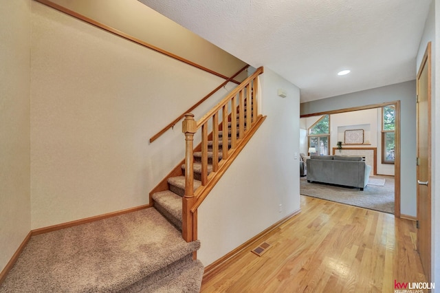 4630 Eagle Ridge Rd, Lincoln, NE 68516 - staircase with wood finished floors, recessed lighting, and a textured ceiling
