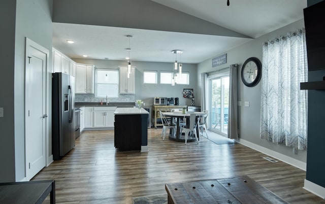 7342 S 184th St, Omaha, NE 68136 - kitchen with stainless steel fridge, vaulted ceiling, white cabinetry, tasteful backsplash, and dark wood-type flooring