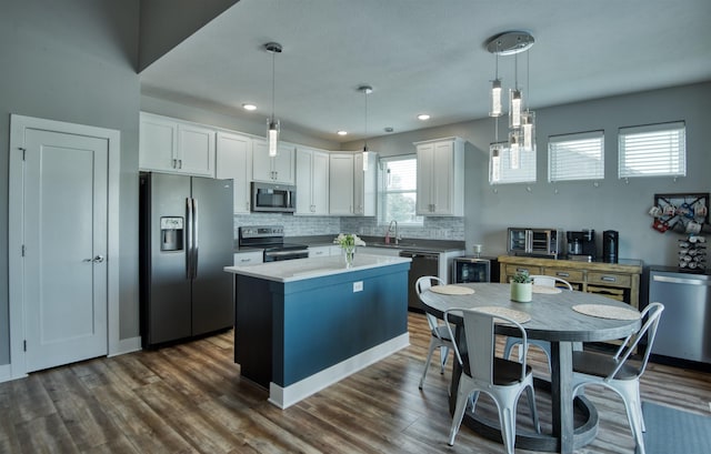 7342 S 184th St, Omaha, NE 68136 - kitchen featuring appliances with stainless steel finishes, white cabinets, a kitchen island, tasteful backsplash, and hanging light fixtures