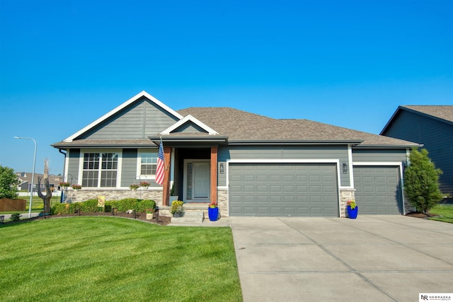 7342 S 184th St, Omaha, NE 68136 - view of front of property featuring a garage, concrete driveway, a front yard, stone siding, and a shingled roof