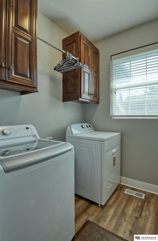 7342 S 184th St, Omaha, NE 68136 - laundry area featuring washing machine and dryer, cabinet space, and wood finished floors