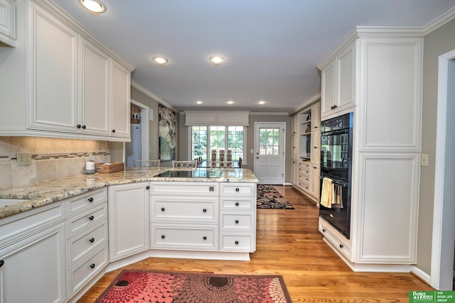 9706 Ascot Dr, Omaha, NE 68114 - kitchen featuring a peninsula, light wood-style flooring, white cabinetry, black appliances, and crown molding