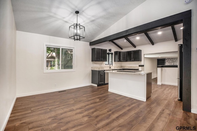 801 Redwood Ln, Papillion, NE 68046 - kitchen featuring dark wood-style flooring, a kitchen island, light stone counters, freestanding refrigerator, and pendant lighting