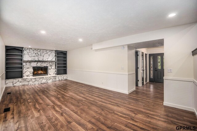 801 Redwood Ln, Papillion, NE 68046 - unfurnished living room featuring built in shelves, wood finished floors, wainscoting, a fireplace, and a textured ceiling