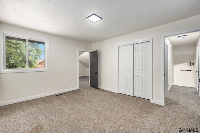801 Redwood Ln, Papillion, NE 68046 - unfurnished bedroom featuring carpet flooring, a closet, and a textured ceiling