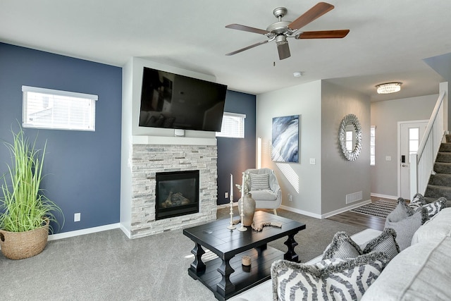 7163 N 164th St, Bennington, NE 68007 - carpeted living area featuring a stone fireplace, stairs, and a ceiling fan