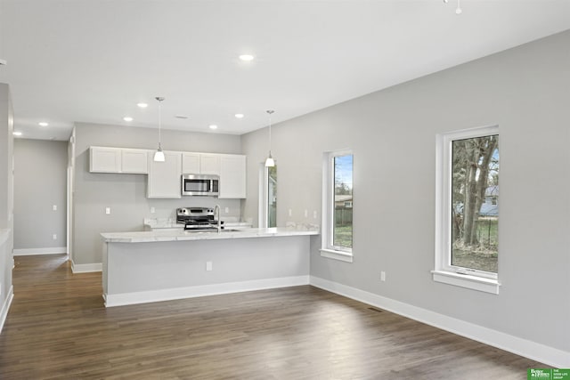 3941 Blondo St, Omaha, NE 68111 - kitchen with stainless steel appliances, white cabinets, light countertops, dark wood-type flooring, and recessed lighting