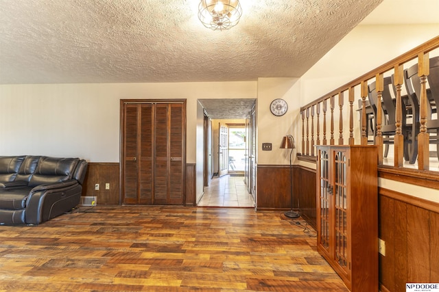 1211 Devon Dr, Papillion, NE 68046 - entryway featuring a wainscoted wall, hardwood / wood-style floors, a textured ceiling, and wood walls