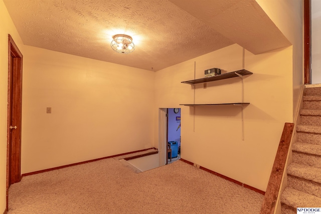 1211 Devon Dr, Papillion, NE 68046 - below grade area with carpet floors, stairway, and a textured ceiling