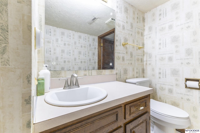 1211 Devon Dr, Papillion, NE 68046 - bathroom with wallpapered walls, vanity, and a textured ceiling