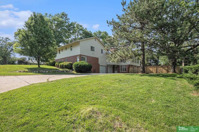 1729 S 76th Ave, Omaha, NE 68124 - view of side of home with a garage, brick siding, and driveway