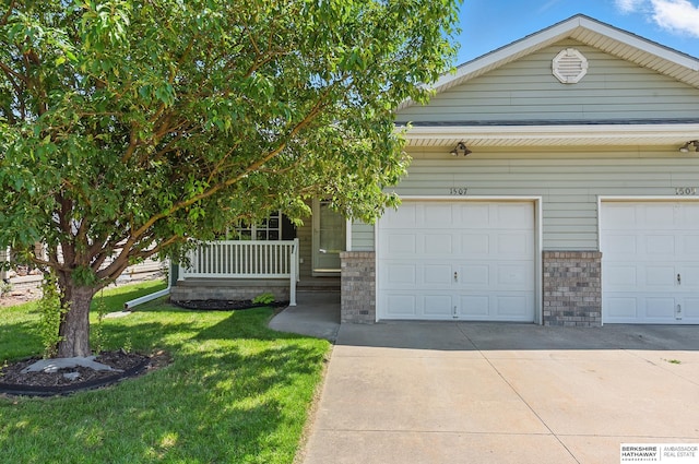 1507 23rd Ave, Council Bluffs, IA 51501 - view of front of property featuring concrete driveway, a front lawn, covered porch, and brick siding