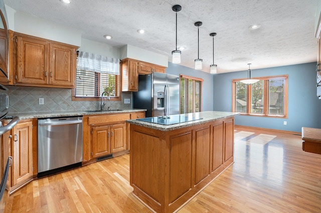 4209 N 158th Ave, Omaha, NE 68116 - kitchen featuring stainless steel appliances, light wood-style floors, decorative backsplash, brown cabinets, and a textured ceiling