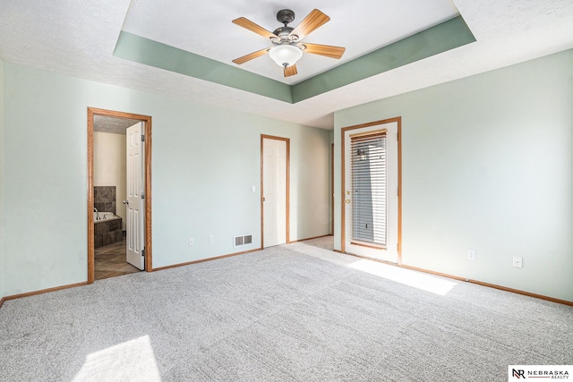 4209 N 158th Ave, Omaha, NE 68116 - unfurnished bedroom featuring carpet flooring, ensuite bathroom, and a tray ceiling