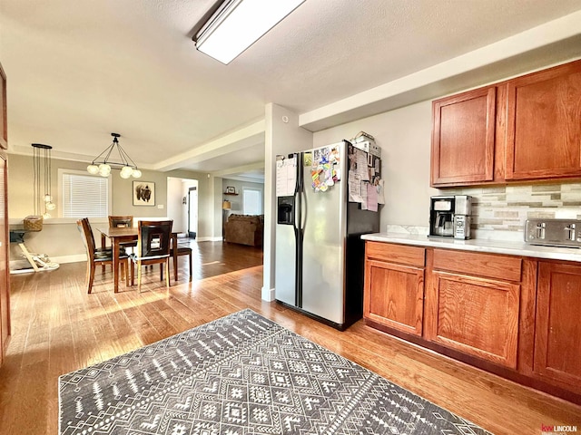 26855 SW 89th Rd, Beatrice, NE 68310 - kitchen with stainless steel fridge, light countertops, a chandelier, and brown cabinetry
