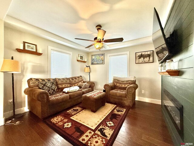 26855 SW 89th Rd, Beatrice, NE 68310 - living room with a glass covered fireplace, dark wood-style flooring, a ceiling fan, and healthy amount of natural light