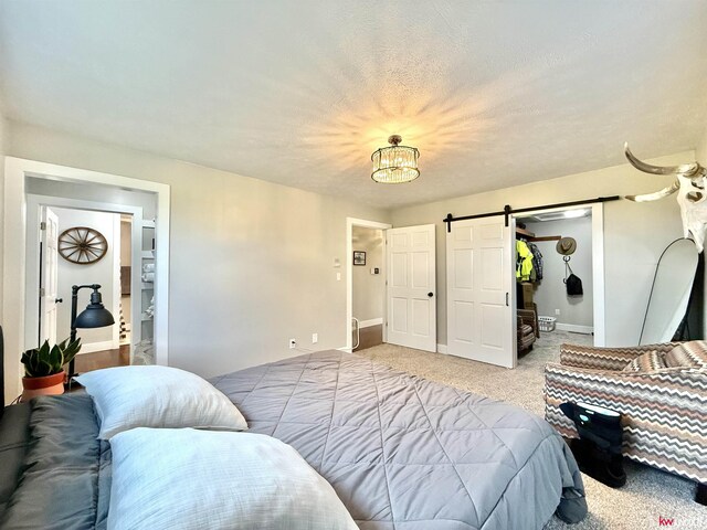 26855 SW 89th Rd, Beatrice, NE 68310 - bedroom with a barn door, light colored carpet, and a chandelier