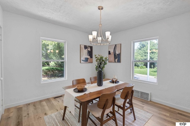 3102 Woolworth Ave, Omaha, NE 68105 - dining area with a chandelier, light wood-style floors, and a textured ceiling