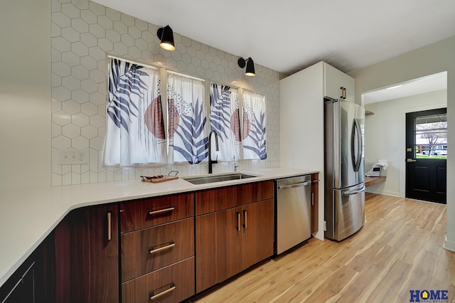 1991 Calvert St, Lincoln, NE 68502 - kitchen with stainless steel appliances, light wood finished floors, light countertops, and tasteful backsplash