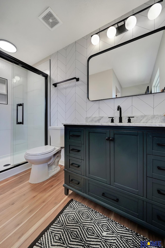 1991 Calvert St, Lincoln, NE 68502 - bathroom featuring vanity, a shower stall, and wood finished floors