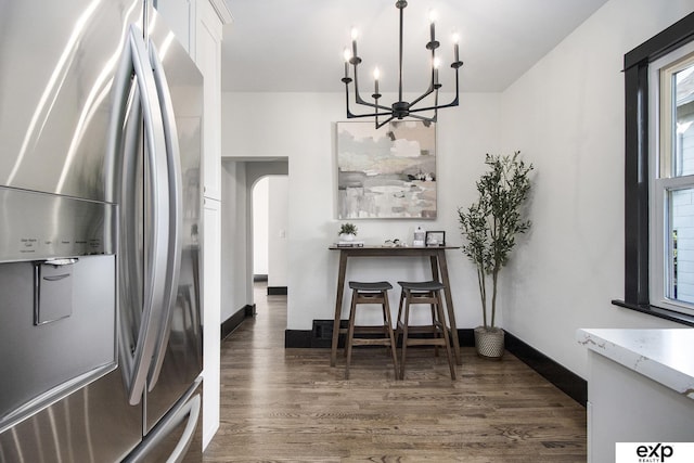 3814 Marcy St, Omaha, NE 68105 - dining room featuring a chandelier, dark wood-type flooring, and arched walkways